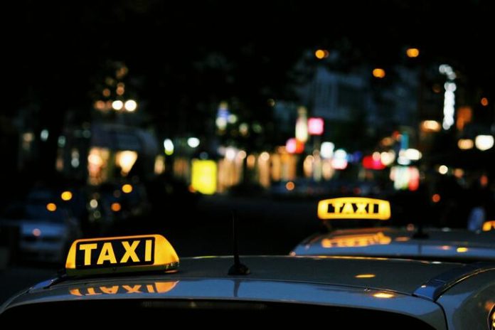 Taxi signs on top of taxi cars at night